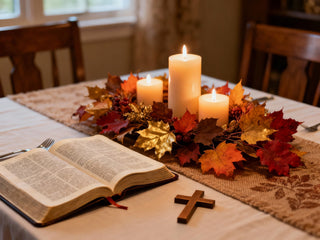 a cozy Thanksgiving table with soft, warm lighting, autumn leaves, and candles as a centerpiece
