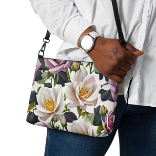 Bed of Roses crossbody bag with cream flowers, purple roses and black trim; close-up worn with a white shirt.