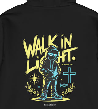 Close-up of the back of a black hoodie featuring a large graphic print with the text 'WALK IN LIGHT.' in yellow, a stylized hooded figure in blue and yellow, a light blue cross, and 'PSALM 27:1' printed below.