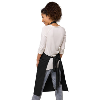 Back view of a black apron with long waist ties knotted in a bow.