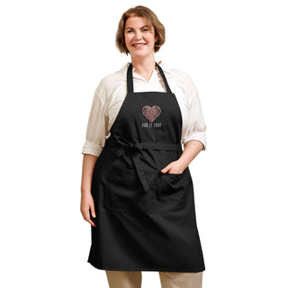 Black God Is Love apron worn with a front waist bow and one hand in the divided pocket.