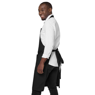 Side view of the black God Is Love apron, showing its length and tied waist straps.