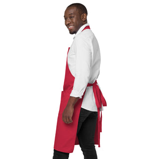 Side view of the red God Is Love apron, showing its length and tied waist straps.