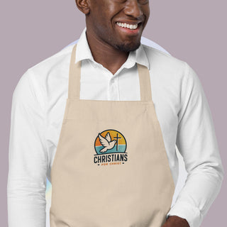 Cream Christians for Christ apron with a dove-and-cross graphic; worn by a model in a white shirt.
