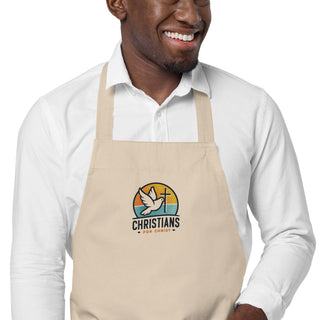 Close-up of a man wearing the beige apron with Christians For Christ dove-and-cross embroidery.