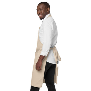 Side view of a man wearing the beige apron, showing the waist ties fastened at the back.