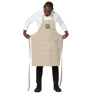 Man holding the beige Christians For Christ apron open to show its front pocket and long waist ties.