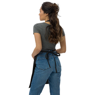 Black apron waist ties fastened in a bow, shown from behind on a model.