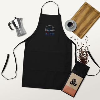Jesus Saves embroidered apron with waves and a small boat design; black apron laid flat with coffee accessories.