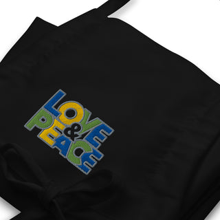 Love & Peace embroidered apron with blue, green, and yellow lettering, black embroidery close-up.