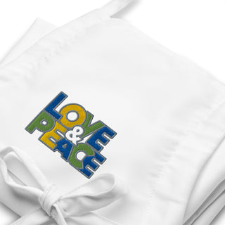 Love & Peace embroidered apron with blue, green, and yellow lettering, white embroidery close-up.