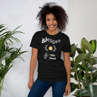 Black T-shirt with Blessed and Highly Favored lettering with a smiling sun, modeled beside plants