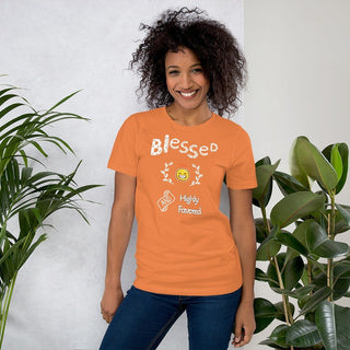 Orange T-shirt with Blessed and Highly Favored lettering with a smiling sun, modeled beside plants