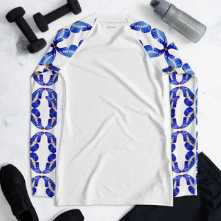Back of white rash guard laid flat beside exercise equipment, showing blue butterfly sleeves