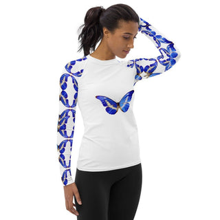 White long-sleeve rash guard with blue butterflies on the chest and sleeves, modeled with one arm raised