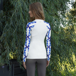Model outdoors showing the plain white back and blue butterfly sleeves of a rash guard