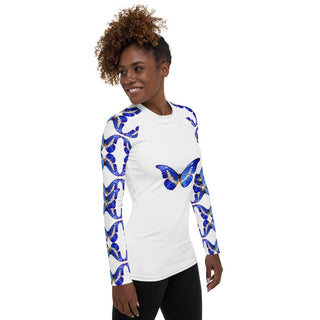 White long-sleeve rash guard with blue butterflies on the chest and sleeves, modeled with black pants, three-quarter view