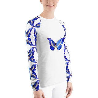 White long-sleeve rash guard with blue butterflies on the chest and sleeves, modeled with white pants, three-quarter view