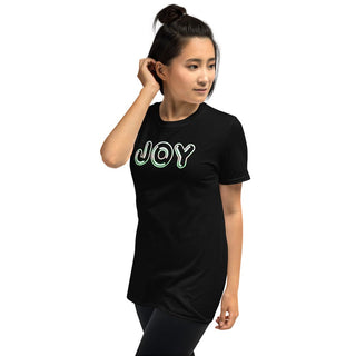Black T-shirt with outlined JOY bubble lettering, modeled with a hand near the ear