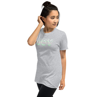 Light gray T-shirt with outlined JOY bubble lettering, modeled with a hand near the ear