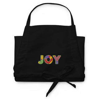 Folded black apron showing multicolored JOY embroidery.