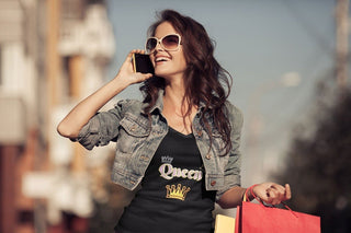 Model wearing a black Queen T-shirt while holding shopping bags